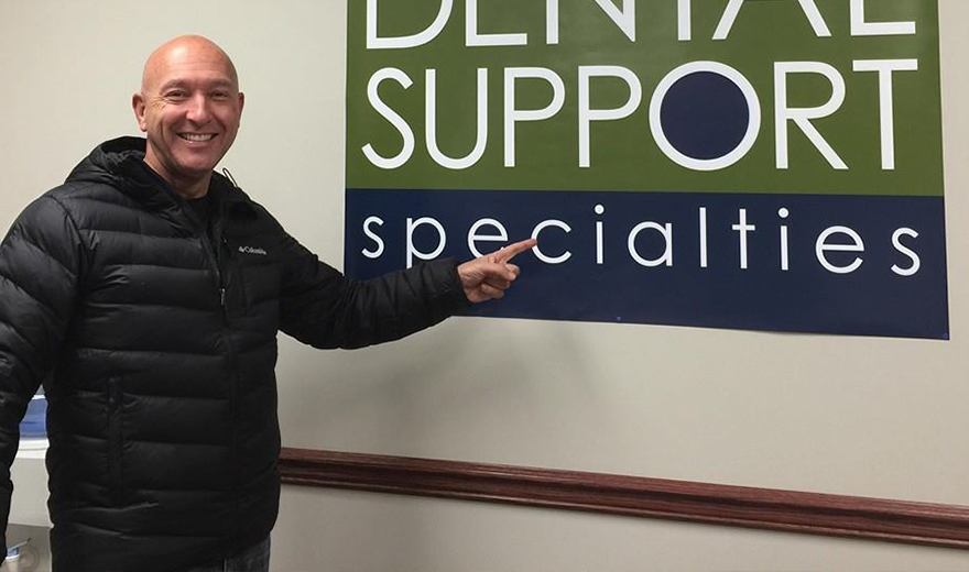 Team member pointing to the Dental Support Specialties sign