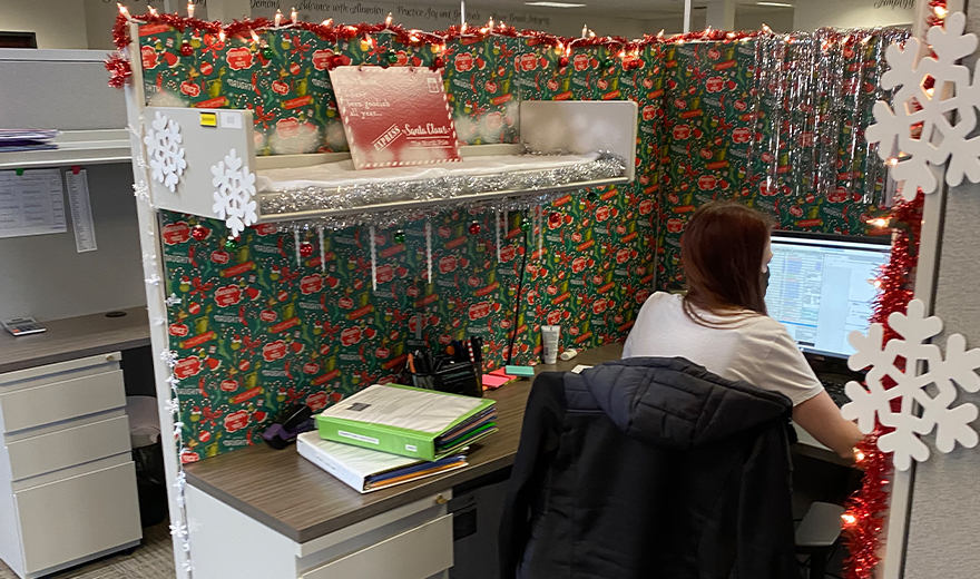 Team member in cubicle decorated for Christmas