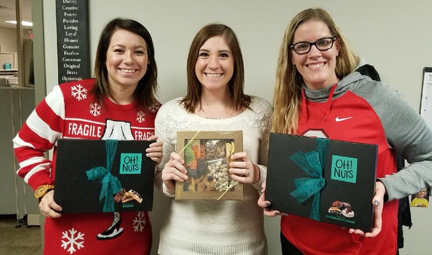 Team members holding holiday gifts