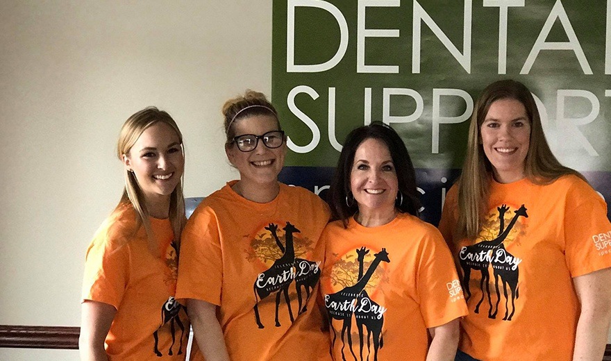 Four team members wearing matching earth day shirts