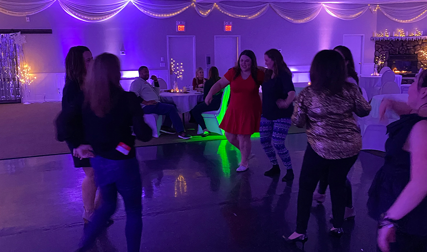 Team members dancing together at community event