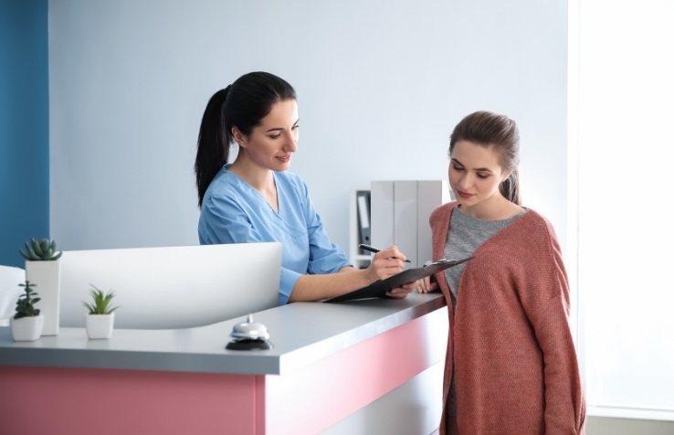 Dental team member and patient reviewing dentistry bill