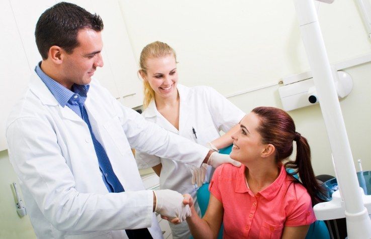 Dentist shaking hands with dental team member