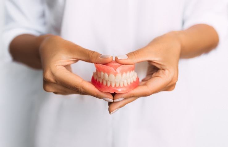 Dentist holding custom dentures