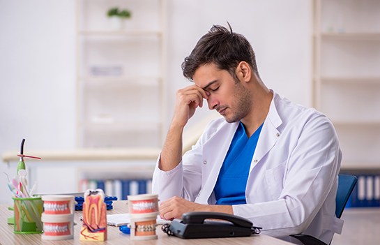 stressed dentist sitting at his desk