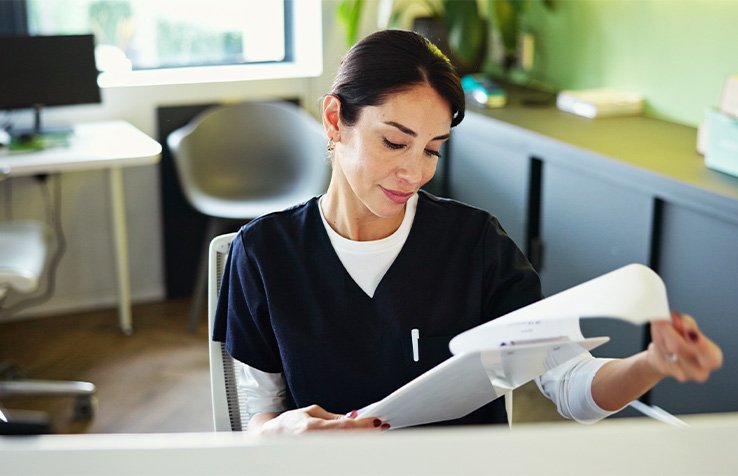 Dental employee looking at paperwork