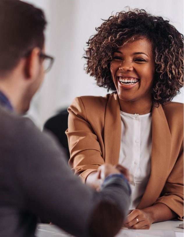 Smiling dental office specialist shaking hands with dentist