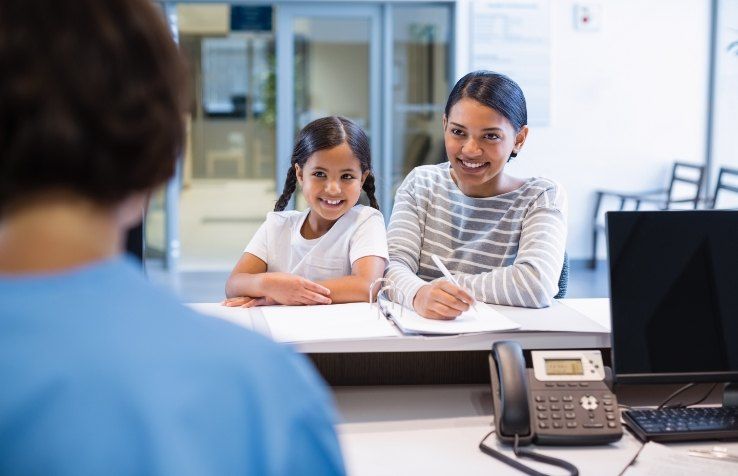 Dental patients checking in at reception desk