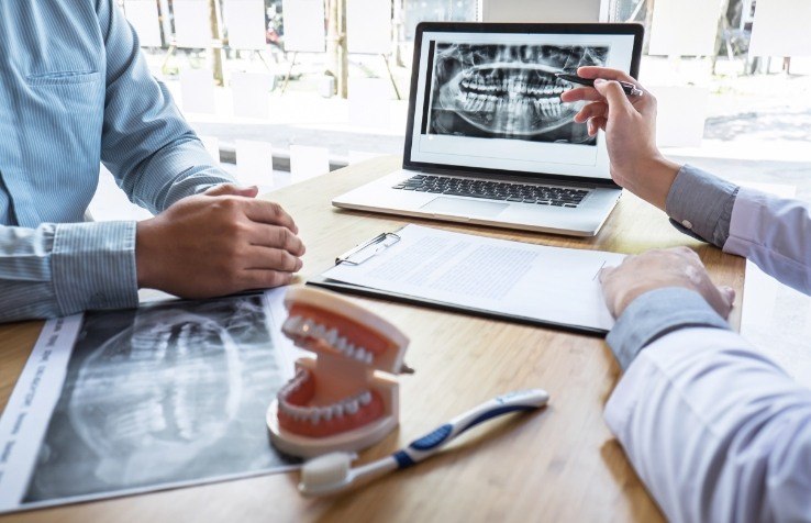 Dentist and team member reviewing patient charts