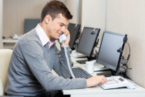 Man answering phones with a smile