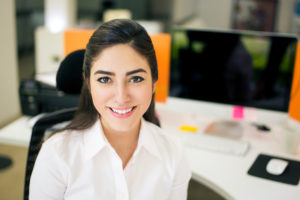 Young smiling woman at work station