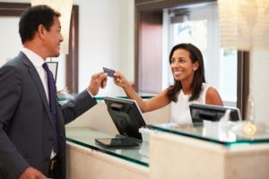 A receptionist handing a patient their credit card.