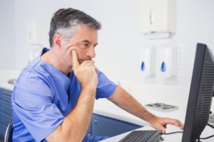 A dentist looking at a computer.