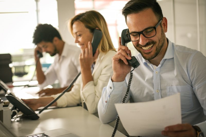 A group of people taking phone calls.