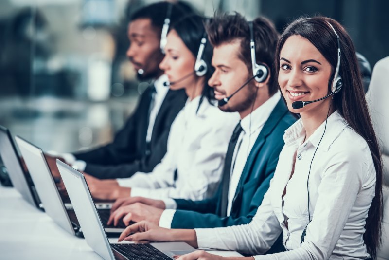 A group of people talking on the phone.