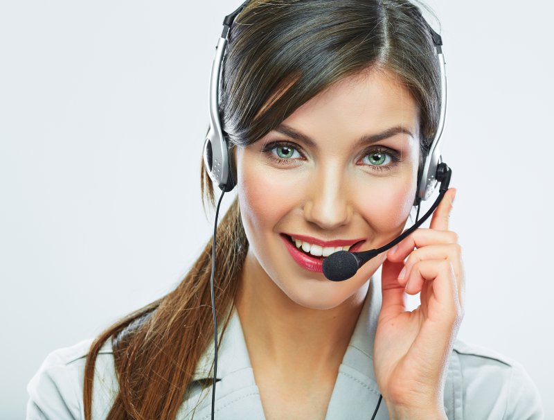 A woman smiling while wearing a headset.