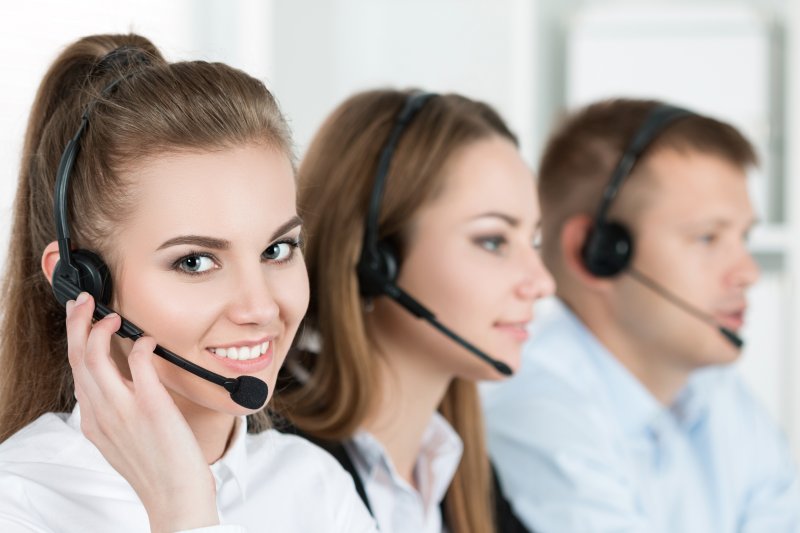 A woman smiling with a group of call center employees.