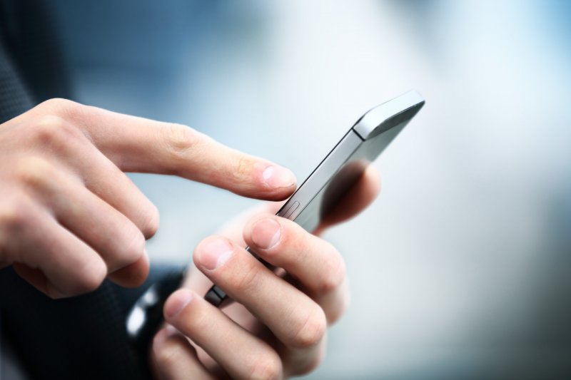 A person dialing a mobile phone.