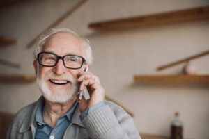 man smiling talking on phone, dental scheduling