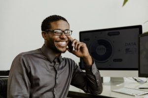 man smiling and talking with dental answering service