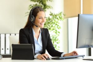 woman smiling while working on dental insurance verification