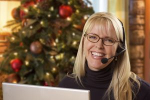 woman answering calls with holiday décor in the background