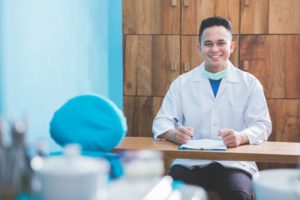 happy dentist sitting at a desk looking at 2023 goals