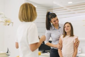 happy mother and daughter talking to team member