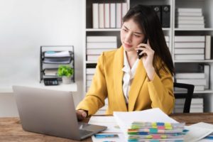 woman looking concerned while on the phone with insurance