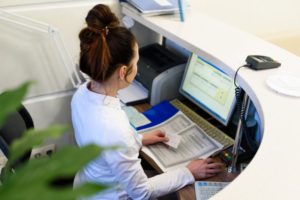 receptionist taking dental insurance information at the front desk