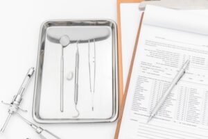 close up of dental instruments and a dental chart