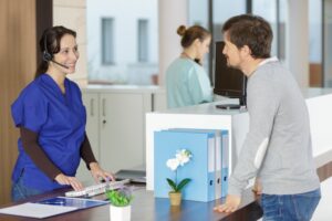 dental front desk team member smiling at a patient