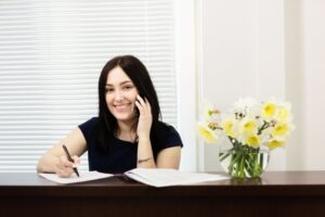 smiling woman at a front desk at the dental office