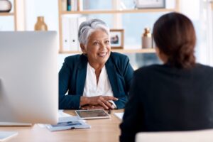 older woman and younger woman talking about dental insurance verification companies
