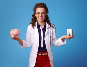 smiling dentist holding a tooth and piggy bank